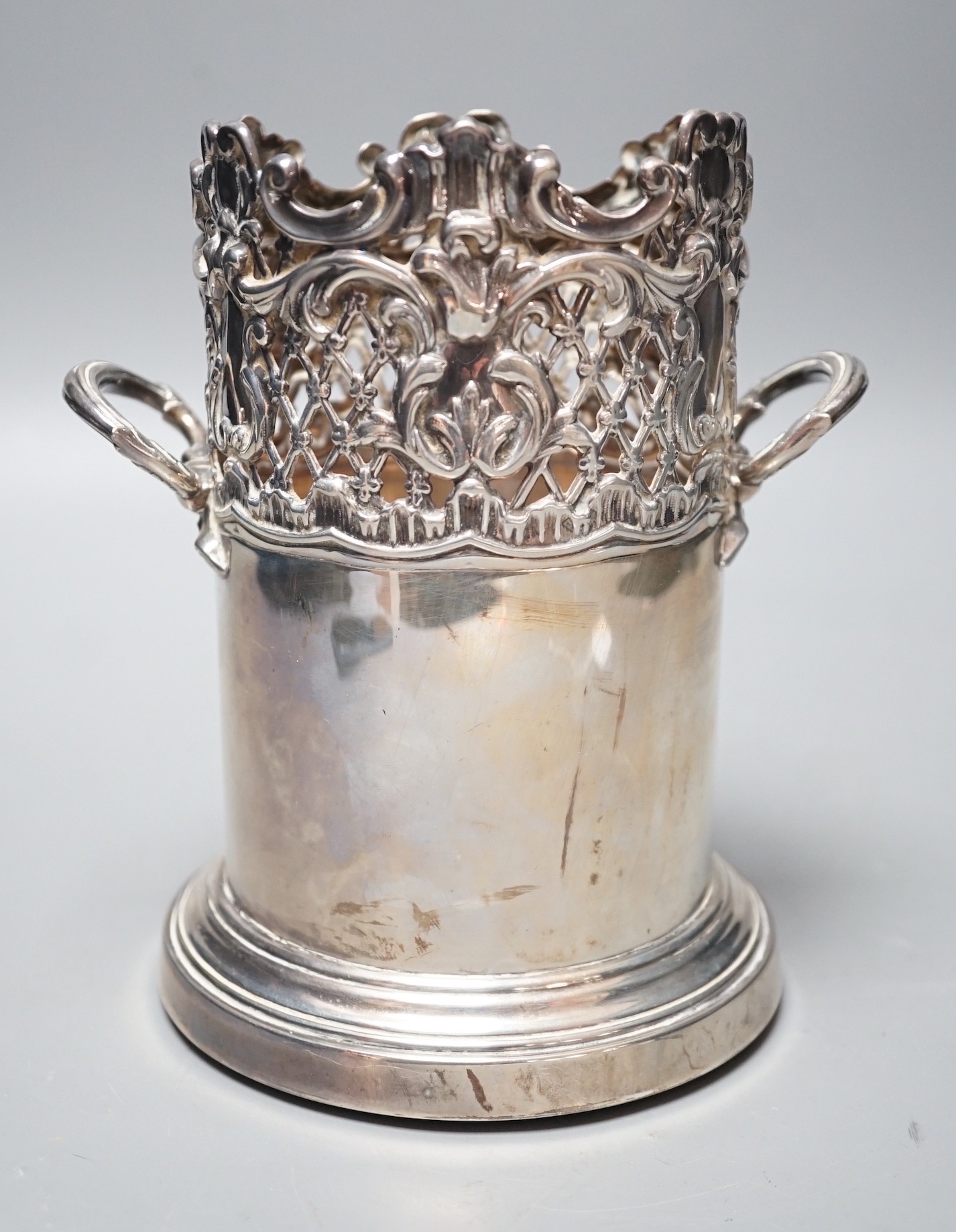 An Edwardian pierced silver mounted two handled syphon stand, by Goldsmiths & Silversmiths Co Ltd, London, 1903, 17.8cm, with turned wooden base.